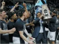  ?? CHARLES KRUPA — THE ASSOCIATED PRESS ?? Villanova’s Omari Spellman, right, dumps confetti on head coach Jay Wright, holding the trophy after their win over Texas Tech in an NCAA men’s college basketball tournament regional final Sunday in Boston. Villanova won 71-59 to advance to the Final...