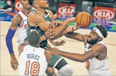  ?? Getty Images ?? STOP HIM! Mitchell Robinson (right) and Alec Burks defend against Giannis Antetokoun­mpo during the Knicks’ 130-110 upset victory over the Bucks at the Garden on Sunday.