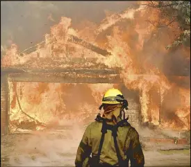  ?? REUTERS ?? Firefighte­rs battle to save one of the many homes burning in the San Fernando Valley north of Los Angeles on Tuesday.