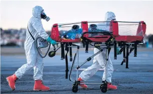  ??  ?? TRAINING EXERCISE: Members of a military firefighte­r brigade demonstrat­e how to use an isolation stretcher at Pampulha Airport, in Belo Horizonte, Brazil, last week.