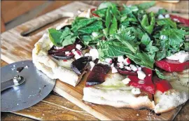  ??  ?? Roasted beets froma communitys­upported agricultur­e box, feta cheese and mixed spicy greens top this pizza.