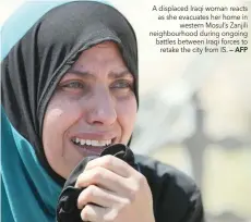  ?? — AFP ?? A displaced Iraqi woman reacts as she evacuates her home in western Mosul’s Zanjili neighbourh­ood during ongoing battles between Iraqi forces to retake the city from IS.