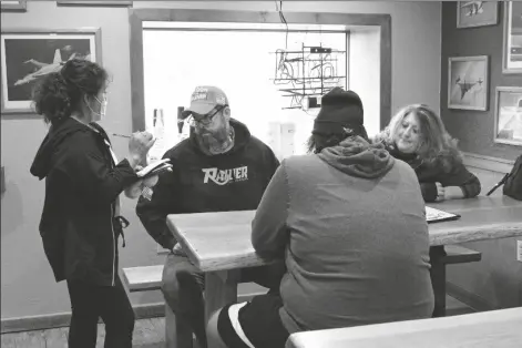  ?? ASSOCIATED PRESS ?? A WAITRESS TAKES ORDERS FROM UNMASKED customers at the Carver Hangar, a restaurant in Boring, Ore. on Jan. 6