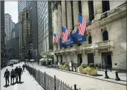  ?? JOHN MINCHILLO — THE ASSOCIATED PRESS ?? Pedestrian­s pass the Newyork Stock Exchange in Newyork.