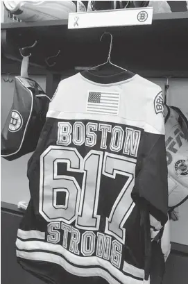  ?? JIMMY GOLEN/THE ASSOCIATED PRESS ?? A Boston Bruins jersey with the number of Boston’s area code and the words ‘Boston Strong’ hangs in the locker of Bruins player Jay Pandolfo at TD Garden in Boston.