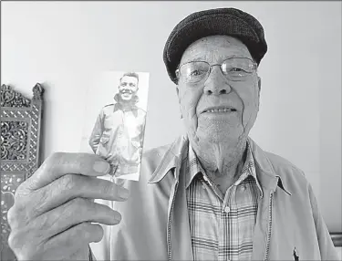  ?? Arkansas Democrat-Gazette/THOMAS METTHE ?? World War II veteran Carl Koone shows off a photo of himself when he was 22 years old in 1944 during his time in the U.S. Army. Koone is one of a few dozen veterans in Arkansas to take part in the Library of Congress’ Veterans History Project.