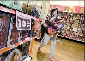  ?? AP/RICHARD DREW ?? A woman carries her purchases in the Toys R Us store in New York’s Times Square in late March.