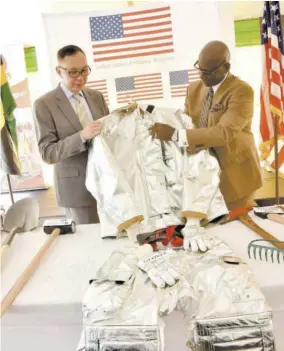  ??  ?? Outgoing United States Chargé d’affaires to Jamaica, Eric Khant, (left) hands over items for the Jamaica Fire Brigade to Minister of Local Government and Community Developmen­t Desmond Mckenzie at a ceremony on Monday.