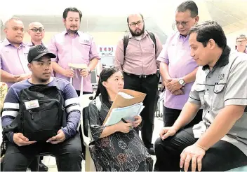  ??  ?? Kamarudin (right) talking to two OKU students, Mohd Zulfadli Aimon bin Sulaiman (left), 20, from Membakut and Wevonny Claudylia Robert, 20, from Manggatal at the registrati­on centre.