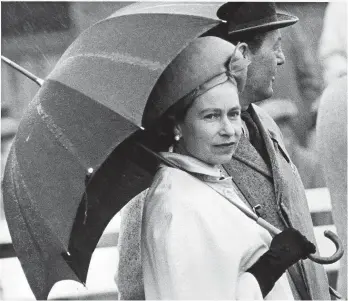  ?? ?? ● Above: Queen Elizabeth II needed her brolly during a trip to Chester Races in May 1966