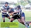  ??  ?? S. Thomas’ prop forward Adeesha Handunpath­irana is well tackled