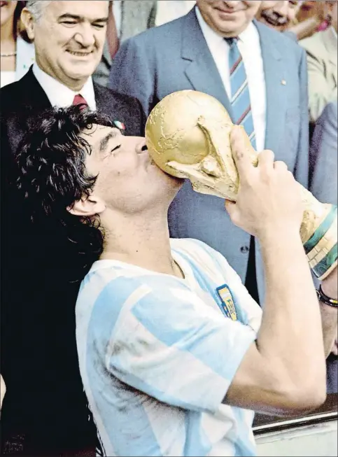  ?? AFP ?? Diego Armando Maradona donant un petó al trofeu de la Copa del Món, el 1986
