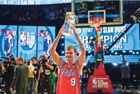  ?? ?? MAC MCCLUNG de los 76ers de Filadelfia levanta el trofeo del concurso de clavadas