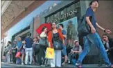  ?? FRANCOIS MORI / ASSOCIATED PRESS ?? Chinese tourists wait for a bus in front of a fashion store in Paris, France, where dozens of visitors have recently been the victims of robbery.