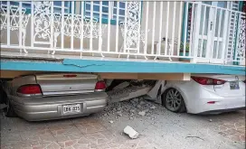  ?? RICARDO ARDUENGO / AFP / GETTY IMAGES / TNS ?? Cars are seen under a collapsed house damaged by a 5.8 earthquake in Guanica, Puerto Rico, earlier this month. Engineers have inspected 561 of the island’s 856 public schools, finding at least 50 too unsafe to reopen.