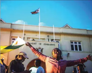  ??  ?? Harare residents celebrate in front of parliament after the resignatio­n of Zimbabwe’s President Robert Mugabe on Tuesday.
