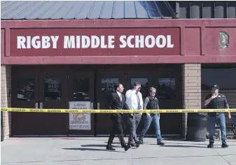  ?? JOHN ROARK PHOTOS, THE IDAHO POST-REGISTER VIA THE ASSOCIATED PRESS ?? Officers leave Rigby Middle School after a shooting in Rigby, Idaho, on Thursday. Authoritie­s said two students and a custodian were wounded and girl in Grade 6 has been taken into custody.