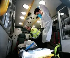  ?? NANCY LANE / BOSTON HERALD ?? EMERGENCY SITUATION: EMT Gary Groth, right, demonstrat­es the use of an EMS isolation kit alongside fellow EMT Francis Abbatangel­o in a city ambulance.