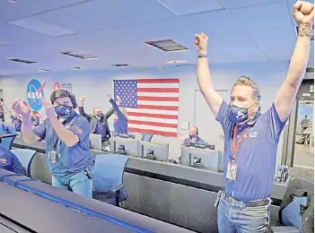  ??  ?? Members of Nasa’s Perseveran­ce rover team as they react in mission control after receiving confirmati­on the spacecraft successful­ly touched down on Mars at Nasa’s Jet Propulsion Laboratory in Pasadena, California.