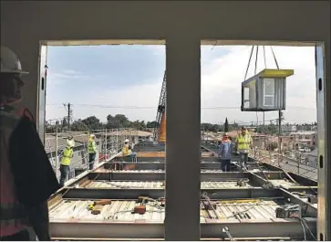  ?? Christina House Los Angeles Times ?? A COMPLEX being constructe­d from shipping containers will shelter 32 homeless people in South L.A.