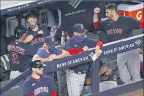  ?? KATHY WILLENS - THE ASSOCIATED PRESS ?? Boston Red Sox’s Xander Bogaerts (2) celebrates with teammates in the dugout after hitting a fifth-inning solo home run in a baseball game against the New York Yankees, Sunday, Aug. 2, 2020, at Yankee Stadium in New York.