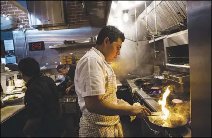  ??  ?? Santana cooks a steak in the kitchen at the St. Francis restaurant, where he worked his way up to chef de cuisine, His skills, hunger to learn and determinat­ion so impressed his boss that the restaurate­ur offered to put him in charge of a restaurant.