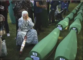  ?? ASSOCIATED PRESS ?? A Bosnian muslim woman, Bahta Aljic, mourns next to the coffin containing remains of her husband who is among 50 newly identified victims of Srebrenica Genocide, Monday, in Potocari.