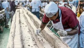  ?? — Photos: AFP relaxnews ?? Hundreds of bakers came together to produce the vanilla cake, which weighed a whopping 27,000 kilos.