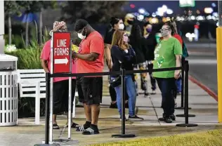  ?? Photos by Robin Jerstad / Contributo­r ?? Adriene, left, and Aaron Roberson wait with others outside the Kohls’s store at the Forum shortly before 5 a.m. for Black Friday shopping to get underway.