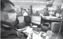  ?? INTERAKSYO­N PHOTO ?? A staff of the Bureau of Immigratio­n screens a returning Filipino in an immigratio­n booth.