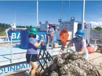  ?? COURTESY ?? Chesapeake Bay Foundation workers use a crane to load recycled oyster shells onto the nonprofit’s new floating restoratio­n facility.