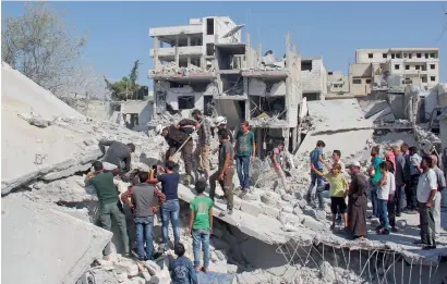  ?? AFP ?? Syrian residents and members of the Syrian Civil Defence, also known as White Helmets, search for victims amid the rubble of a building following a reported overnight air strike in the rebel-held town of Armanaz, in Idlib province near the Turkish...