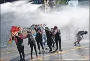  ?? Pablo Vera AFP/Getty Images ?? DEMONSTRAT­ORS are sprayed with water by police in Santiago. Protests have spread across Chile.