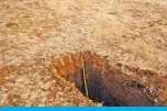  ??  ?? PRETORIA: Photo shows a stick measuring the depth of a newly dug grave at the Honingnest­krans cemetery, in Pretoria, for victims of the COVID-19. — AFP