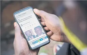  ?? SIMON WOHLFAHRT AFP/GETTY IMAGES ?? A man looks at his smartphone in Kigali, Rwanda, on Monday, showing an article on the arrest of Félicien Kabuga, one of the last key fugitives wanted over the 1994 Rwandan genocide.