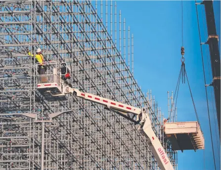  ?? Picture: GLENN HAMPSON ?? Workmen dismantle scaffoldin­g at the Gold Coast Aquatic Centre after the Commonweal­th Games.