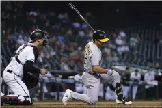  ??  ?? The A’s Ramon Laureano, right, strikes out as Diamondbac­ks catcher Carson Kelly, left, holds the baseball during the seventh inning Tuesday in Phoenix.