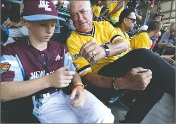 ?? (File Photo/AP/Gene J. Puskar) ?? Hurdle (right) hands a commemorat­ive pin to Barrington, R.I., player Owen Pfeffer in the stands at Lamade Stadium as they watch a baseball game at the Little League World Series tournament in South Williamspo­rt, Pa. A major league player for 10 years and a manager for 17 more before getting fired by the Pirates in September, Hurdle was known throughout baseball for his positive approach — with a big personalit­y and frame to match.