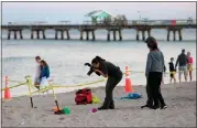  ?? MIKE STOCKER — SOUTH FLORIDA SUN-SENTINEL VIA AP ?? Investigat­ors on the beach in Lauderdale-by-the-Sea, Fla., take photos of the scene of a sand collapse on Tuesday.