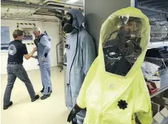  ?? JOHN THYS / AFP / GETTY IMAGES ?? A man tries on an air-permeable charcoal-impregnate­d suit during a chemical-weapons simulation.