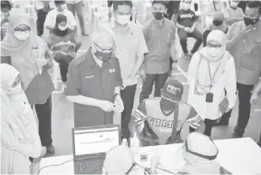  ?? — Gambar Bernama ?? TINJAU KEADAAN: Ismail Sabri (tiga kiri) melihat proses pendaftara­n para penerima vaksin, ketika melawat PPV di Pejabat Daerah dan Tanah, Bandar Seri Jempol di Jempol, semalam.