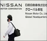  ?? ?? A man walks in front of Nissan headquarte­rs Thursday, May 12, 2022, in Yokohama near Tokyo. Japanese automaker Nissan returned to profitabil­ity in the last fiscal year for the first time in three years, despite challenges such as supply shortages caused by the pandemic and soaring costs. (AP)