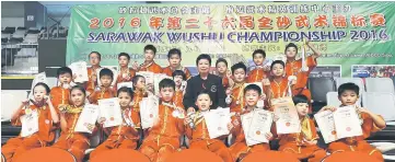  ??  ?? Organising chairperso­n Wong Hua Yiing, who is also Kelab Wushu Permai Timur president, poses with athletes from Sibu.