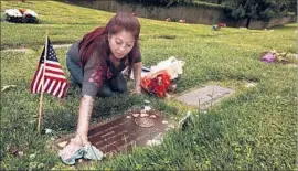  ?? Genaro Molina Los Angeles Times ?? DARLENE GUZMAN of Lincoln Heights cleans the grave of her daughter Bree’Anna Guzman, 22, who went missing the day after Christmas in 2011.