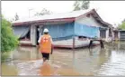  ?? SAMOA RED CROSS/AFP ?? A Samoa Red Cross worker checks on a house yesterday in the Apia area on a flooded street after Cyclone Gita wreaked havoc on the island on.