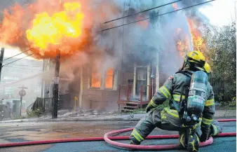  ?? KEITH GOSSE • THE TELEGRAM ?? A firefighte­r from St. John’s Regional Fire Department steadies a hose onto a home on Lime Street engulfed in fire Monday morning, Oct. 30.