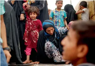  ?? AFP ?? Displaced people get out of a truck as Iraqi forces battle Daesh militants in western Mosul. —