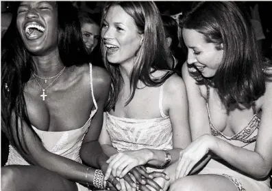  ??  ?? Naomi con Kate Moss e Christy Turlington durante la sfilata-tributo a Versace a Capetown, 14 febbraio 1998. Nella pagina accanto. Gianni Versace con le sue top model negli anni 90.