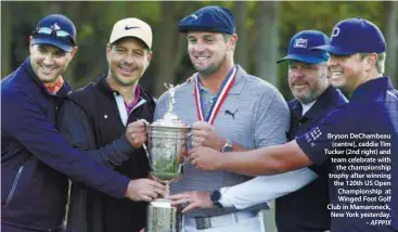  ??  ?? Bryson DeChambeau
(centre), caddie Tim Tucker (2nd right) and team celebrate with
the championsh­ip trophy after winning the 120th US Open Championsh­ip at Winged Foot Golf Club in Mamaroneck, New York yesterday.
– AFPPIX
