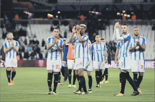  ?? PICTURE: PA ?? DISAPPOINT­MENT: Huddersfie­ld Town players applaud their fans after losing in the Premier League for the first time last night at the London Stadium.